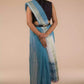 woman wearing a blue saree and a black blouse with stripes at the border and a belt