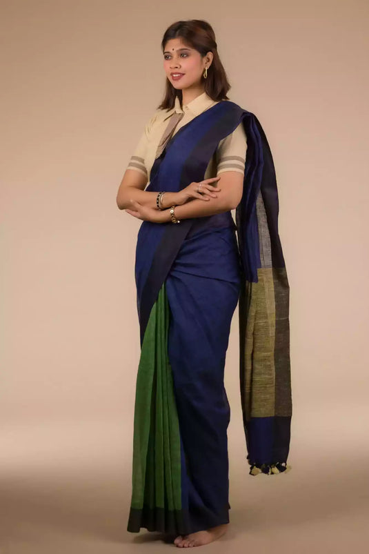 side view of a beautiful woman wearing a multicolor saree with brown blouse and gold accents on the border, and hands being folded