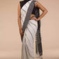 Side view of a woman wearing white saree with black stripes on it
