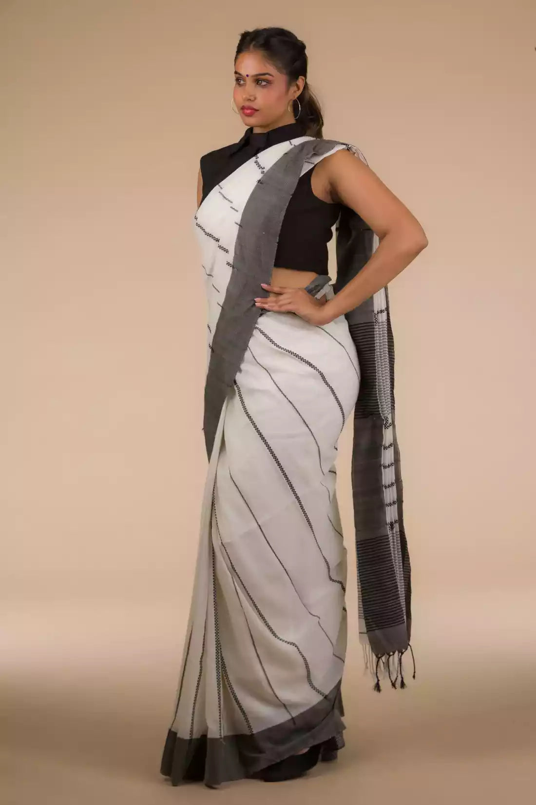 a woman in a white saree with black stripes on it 