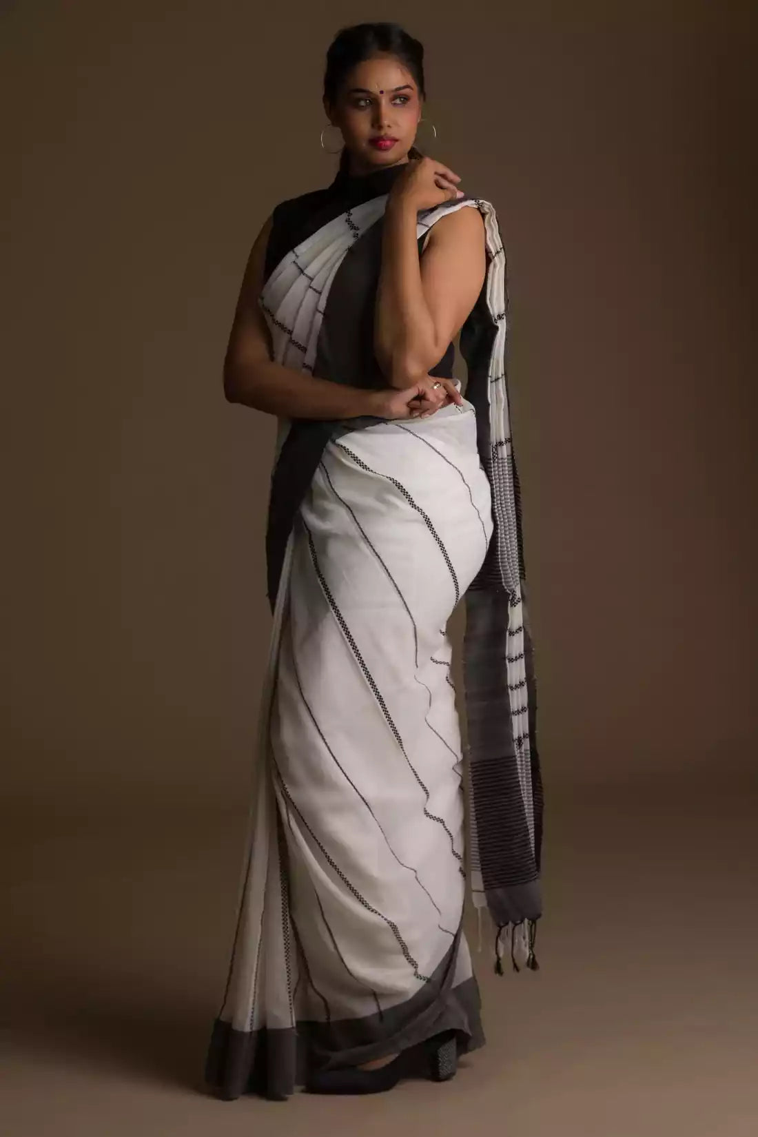 a woman in a white saree with black stripes on it