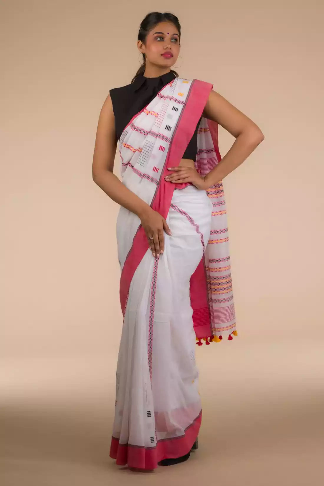 a beautiful woman wearing in White & Red In Cotton Saree, women workwears is posed in front of a tan background