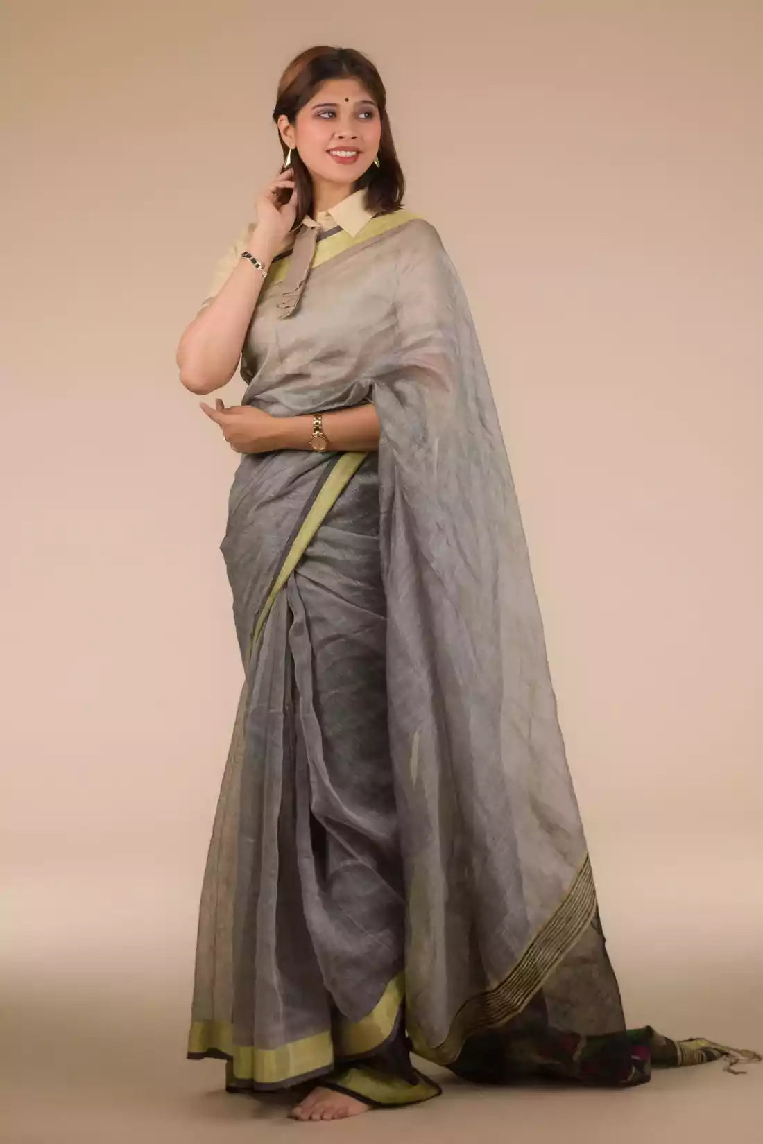 A lady in Grey Silk Linen Jamdani hand weaving Saree standing against a beige background