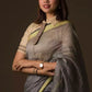 A lady in Grey Silk Linen Jamdani hand weaving Saree standing against a beige background