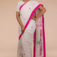 front view of a woman wearing a white saree with pink polka dot work on it and the bottom half