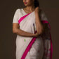 a woman standing in a white saree with pink polka dot work on it and the bottom half