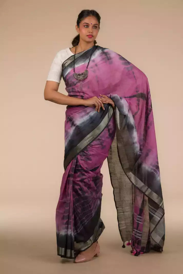 a beautiful woman wearing a Shibori In Cotton Viscose Saree, women workwears is posed in front of a tan background