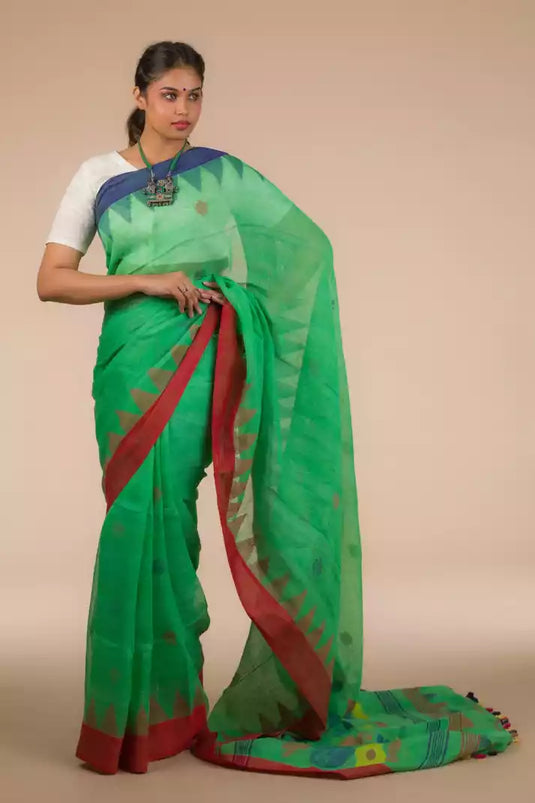 This a photo of beautiful woman wearing a Green Jamdani hand weaving In Pure Linen Saree, women workwears is posed in front of a tan background
