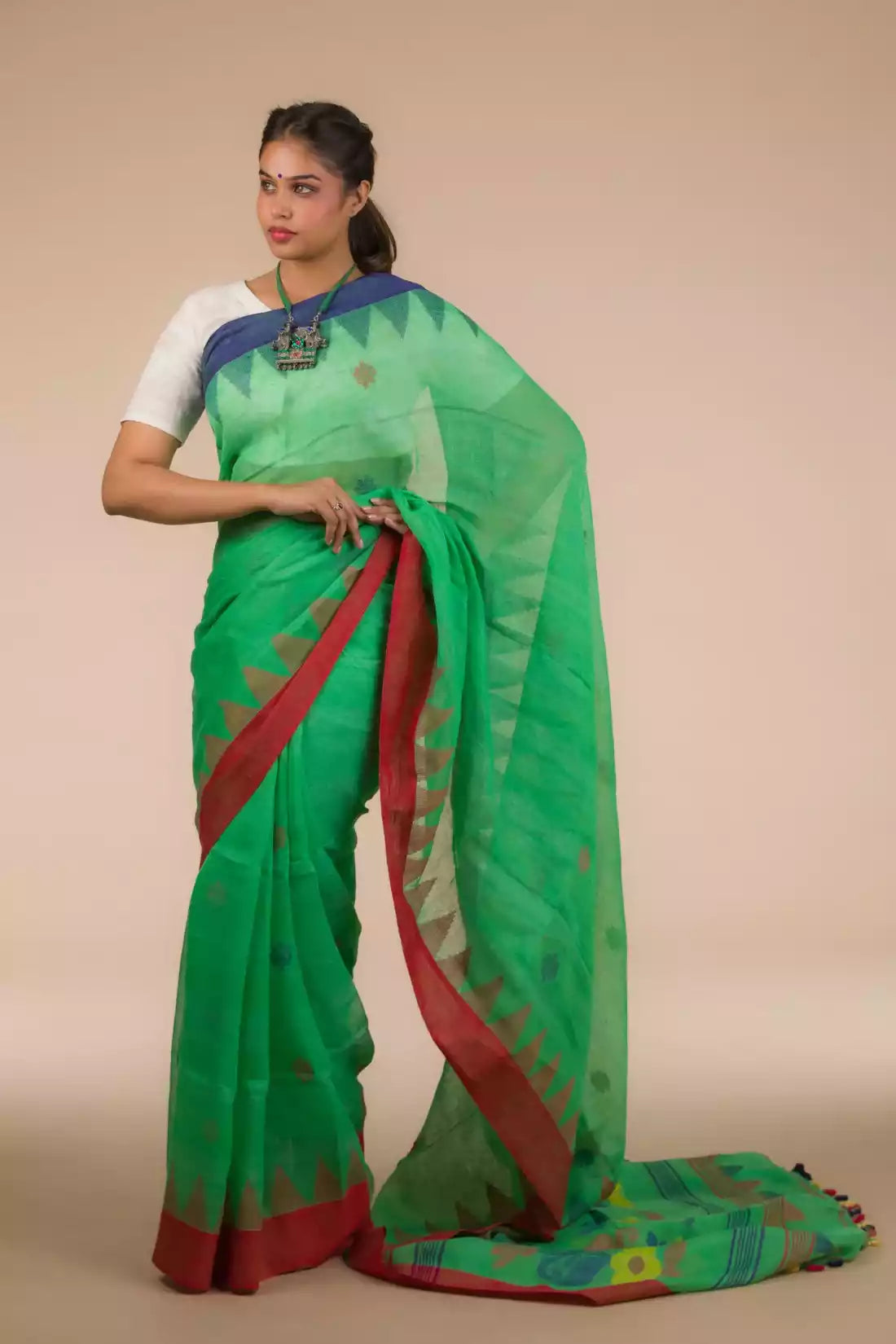 A lady in Green Jamdani hand weaving In Pure Linen Saree, womens workwear standing against a beige background