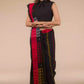 a front view of a woman standing in an ethnic black and red saree with striped fabric on the bottom