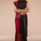 a woman standing in an ethnic black and red saree with striped fabric on the bottom