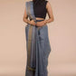 an image of a woman in a grey saree with dark colored sleeveless blouse and a belt around her waist
