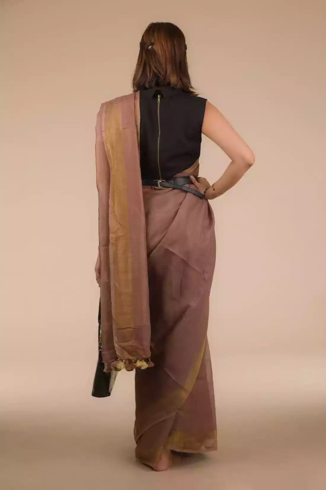 This is the image of the back view of woman in chestnut brown saree 