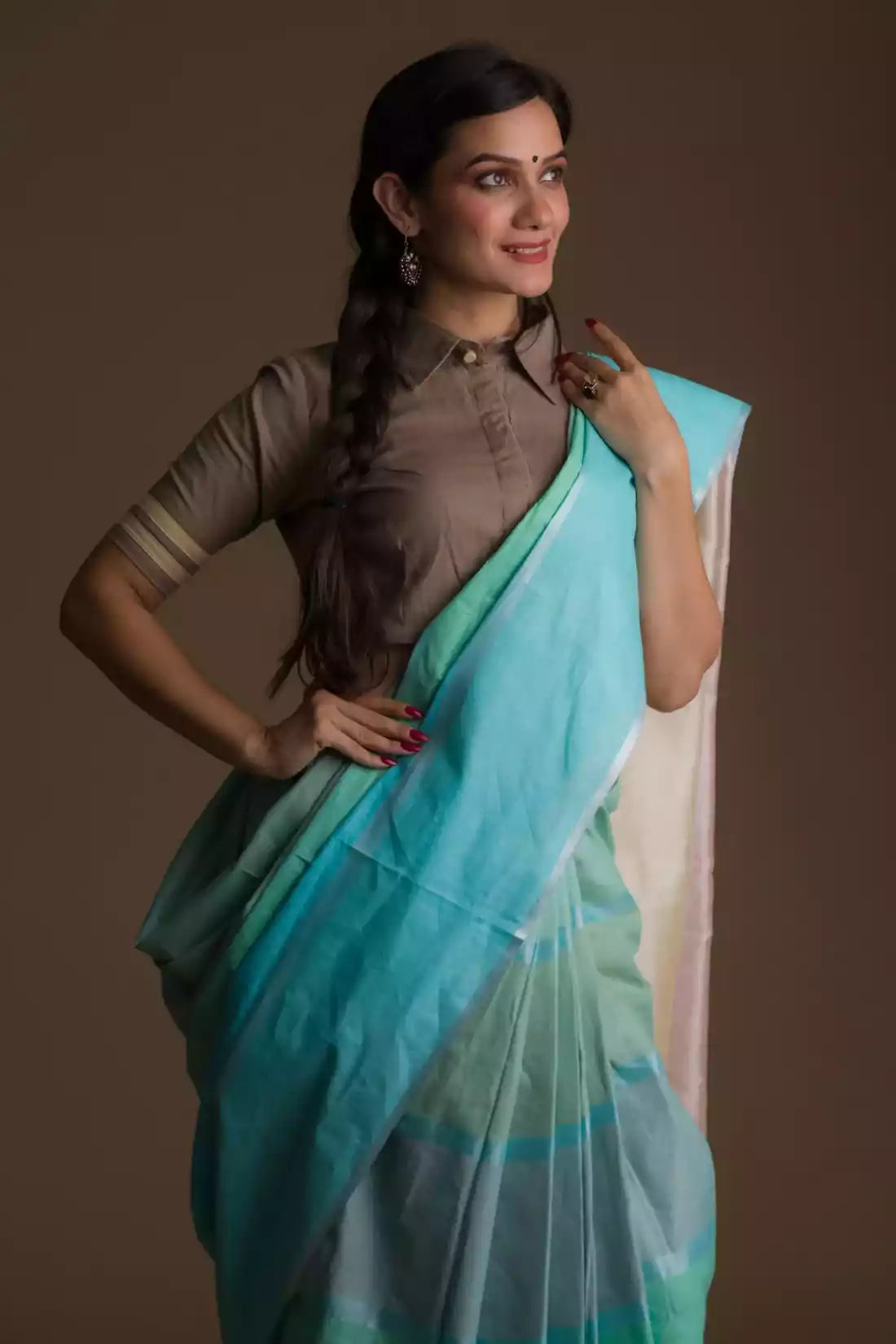 A lady in Pure Cotton Horizontal stripes Casual Saree, womens workwear standing against a beige background looking sideways