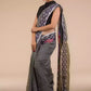 a woman looking sideways wearing formal workwear Grey with ikkat border In Pure Cotton Saree