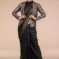 A lady in Indy Ebony Linen Saree in black, womens workwear standing against a tan background looking  down