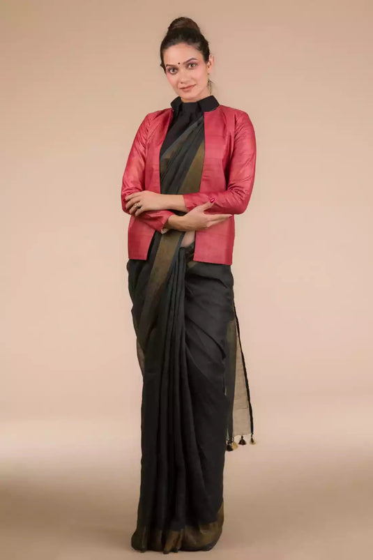 This a picture of a woman wearing a Indy Ebony Linen Saree in black, women workwears is posed in front of a tan background