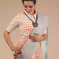 a beautiful woman with a bun wearing a multicolor pastel saree with multicolor blouse and blue jewellery posing by looking down